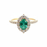 Selman's Jewelers 14k yellow gold oval emerald and diamond halo ring with 0.59ctw diamonds. May birthstone.