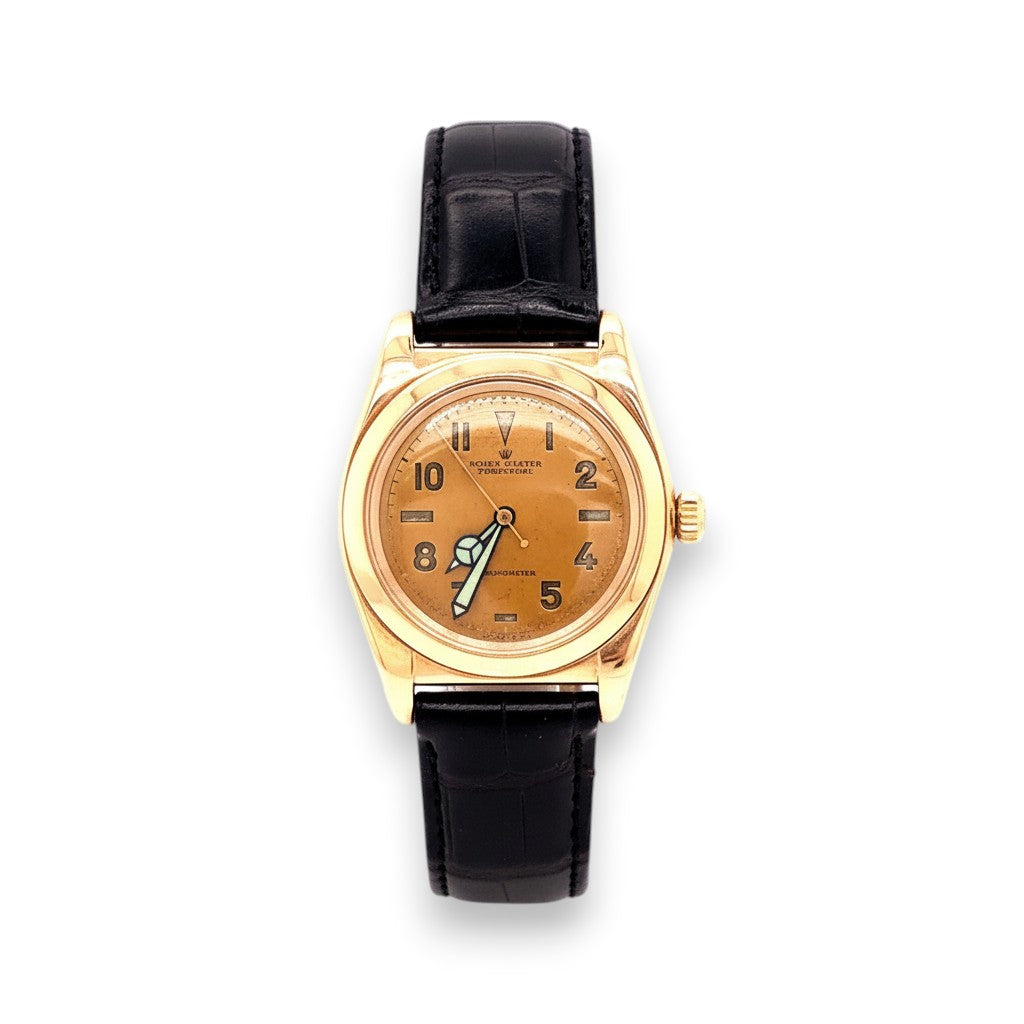 Selman's Jewelers 14K gold Rolex Perpetual Bubbleback wristwatch with a brown dial and black alligator strap.